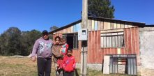 Família em frente de casa em bateias ao lado do poste da cocel campo largo
